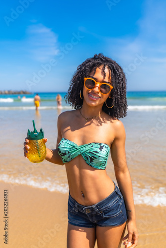 Happy young woman enjoying tropical beach vacation drink