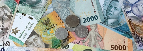 Tableau sur toile Indonesian rupiah money banknotes and coins on table