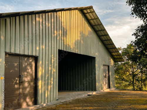 Large industrial-style building with a gabled roof used as a stable facility.
