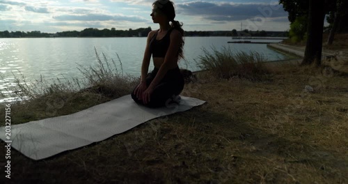 Engaging in a Serene and Rejuvenating Yoga Practice by the Waters Edge During Sunset
