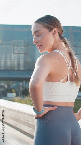 Back view of athletic fitness motivated runner girl training marathon run, check time starting race showing thumb up. Workout cardio in park. Young woman enjoy jogging. Active sportswoman jogger.