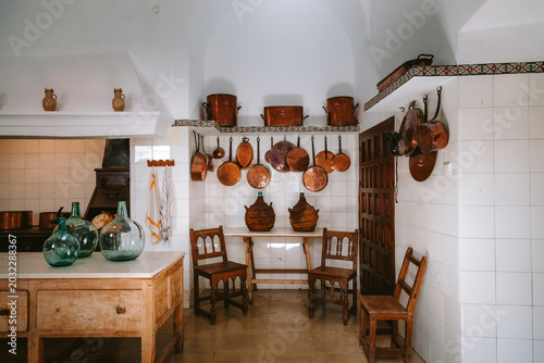 Foto Rustic Cordoba kitchen interior with white tiled walls, antique wooden counter a
