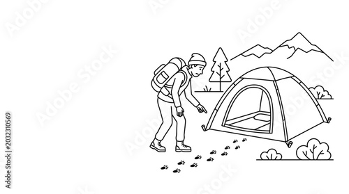 Photos A young hiker discovering animal footprints near his camping tent in the mountains