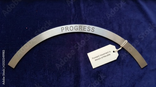 Metal Arch Inscribed with the Word Progress and a Motivational Tag