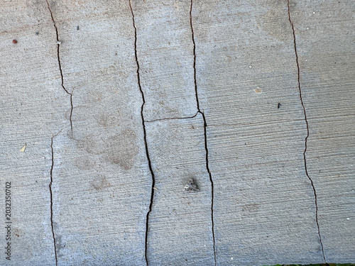 Foto Aged Gray Cement Pathways Presenting a Tapestry of Deep Fissures and Minor Surfa