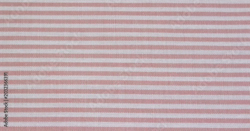 Close up of classic pink and white striped fabric. Texture of pink horizontal striped cotton cloth background. 