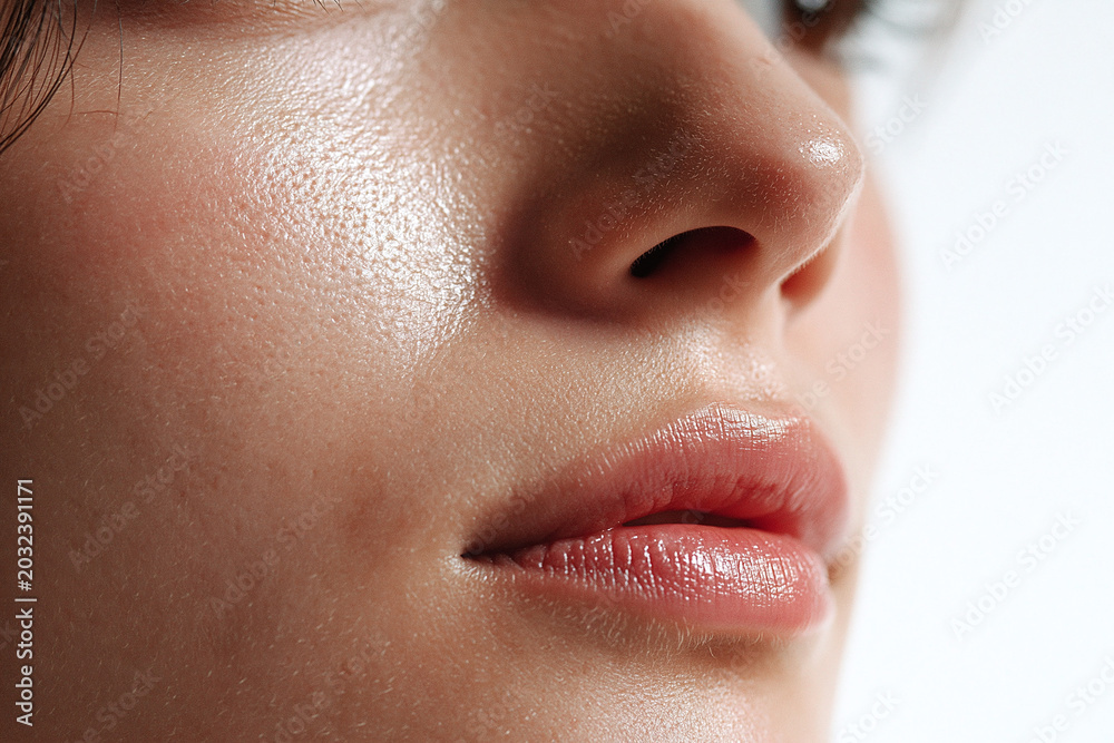 Obraz premium Close up of natural Japanese skin with visible pores and soft reflective glow on cheek and lips, subtle moisture and smooth texture conveying healthy skincare and intimate beauty