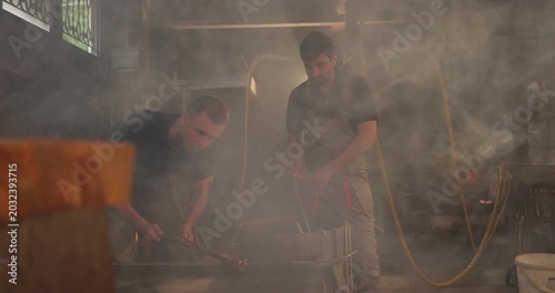 Foundry Workers Pouring Molten Metal in Traditional Casting Workshop