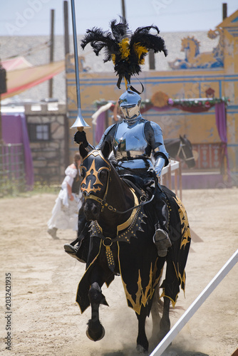 Foto A knight in polished silver armor rides a black horse during a medieval jousting