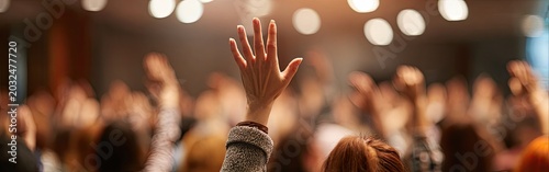 Hand raised in a crowd, responding to a question or participating in an event