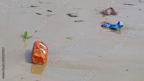 Ugly tropical beach pollution with floating trash and washed ashore rubbish Thailand.
