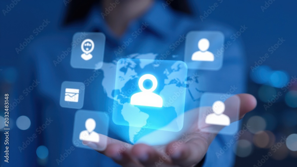 Naklejka premium Global Network of People: A hand holds a glowing holographic earth, surrounded by icons of people and a message icon, symbolizing interconnectedness and global communication.