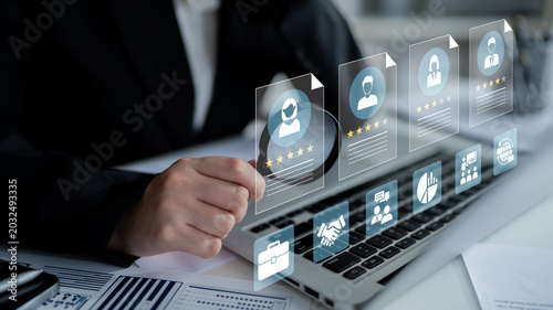 Tableau sur toile A business professional is assessing performance metrics and user profiles on a laptop, surrounded by digital elements in a modern office environment