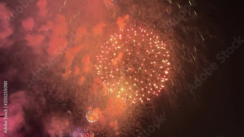 Colorful fireworks burst in the night sky, vibrant gold, green, and blue colors. The display creates a festive atmosphere, illuminating the dark background. July 4, 2026 U.S. Independence Day. Footage