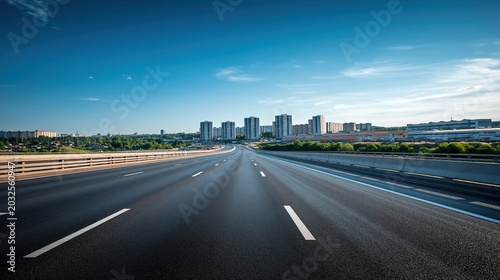 Empty highway vanishing into a distant cityscape under a clear blue sky, symbolizing travel and progress.
