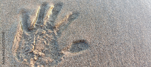 Valokuva Close-up of a distinct human handprint deeply impressed in the soft, moist beach