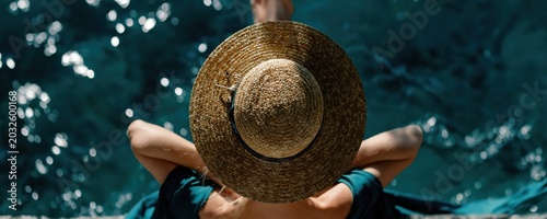 A cinematic rear-view of two people lounging seaside in straw hats, basking in sunlight. Dreamy tropical escape with turquoise water creates a high-end resort vibe.