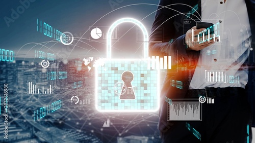 Photos A businessman in a suit holds a smartphone while surrounded by digital graphics showcasing cyber security and data protection trends in a city backdrop