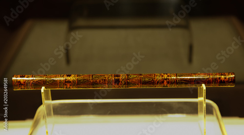 Tableau sur toile Indigenous ceremonial wooden stick with tribal patterns on museum display stand