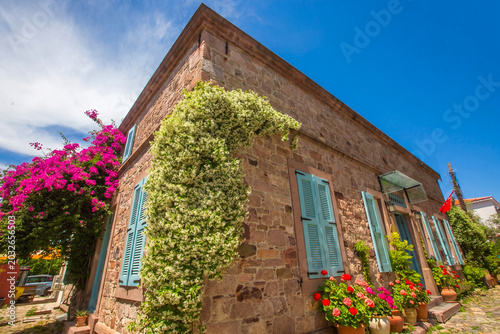 Tableau sur toile Ayvalik - Turkey, May 17, 2026, Historic Stone Mansion with Blue Shutters and Ja