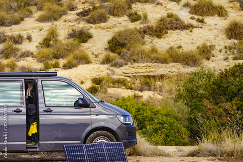 Portable solar photovoltaic panel, charging battery at camper van vehicle.