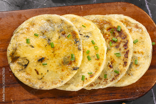 Foto Traditional Chinese Scallion Pancakes with Dried Vegetables on Wooden Board