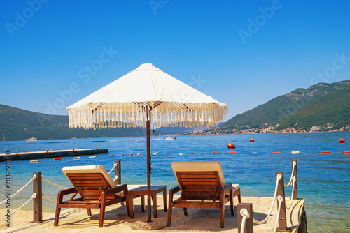 Beach vacation, chaise lounges and beach umbrella. Montenegro, coast of  Bay of Kotor,  Tivat. Copy space