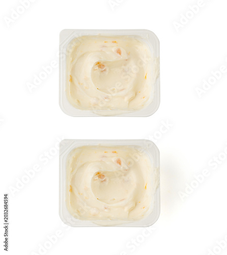 Yogurt cup isolated, yoghurt with orange fruits pieces in plastic pot, milk pudding container
