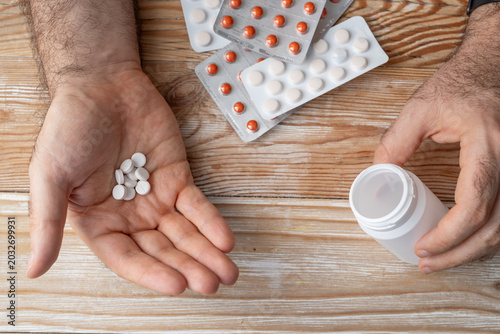 Obraz na płótnie Pills in hand top view, taking painkillers, white medical tablets