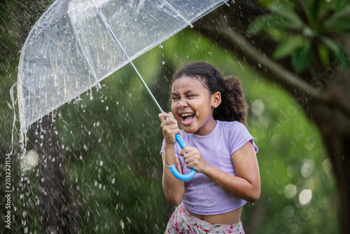 Young Girl Holding Transparent Umbrella During Rainy Season in Tropical Nature