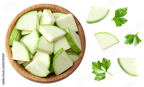 sliced zucchini or marrow in wooden bowl isolated on white background. clipping path