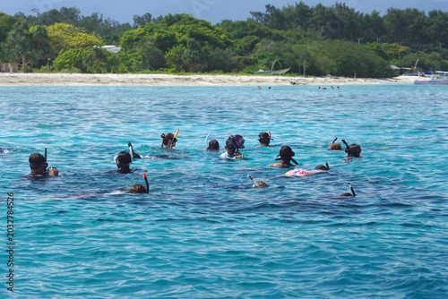 Snorkelers in turquoise Gili Meno waters