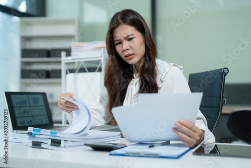 Stress businesswoman is sitting at table, under stress from working.