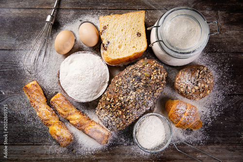 Cuadro en lienzo Fresh baked bread and baking ingredients on rustic table