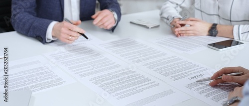 Foto Business people discussing contract terms, outlining agreements, and reviewing l
