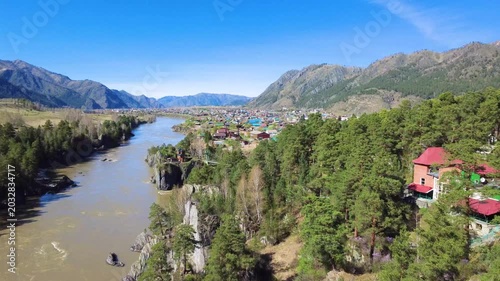 Colorful Rooftops In Forest Village. Elevated View Of Colorful Rooftops Within Lush Pine Forest. Aerial Perspective Capturing Quaint River Valley Village With Vibrant Roofs And Towering Pines