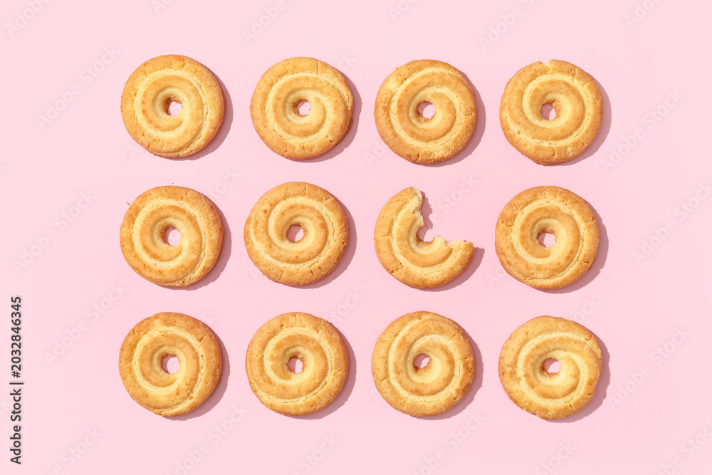 Fototapeta premium Many tasty spritz biscuits on pink background, top view