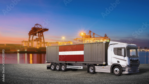 Schilderij op canvas Container Truck with Latvian Flag at Port: A modern container truck displaying the Latvian flag is parked at a bustling port