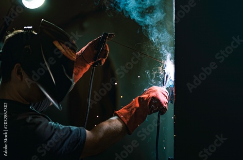 Photos Under dim lights, a talented welder uses a powerful tool to fuse metal with skillful hands
