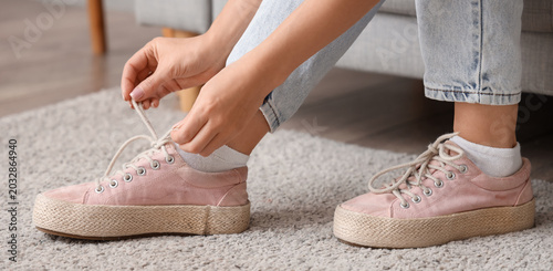 Foto Woman in pink sneakers at home, closeup