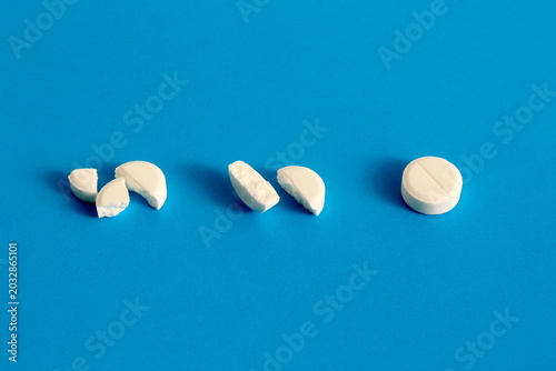 There are several white tablets on a blue background.