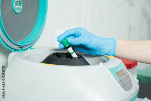 Obraz na plátně Lab Worker Placing Blood Sample Test Tube in Centrifuge Machine