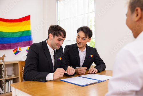 Grooms meeting officiant with Pride flag