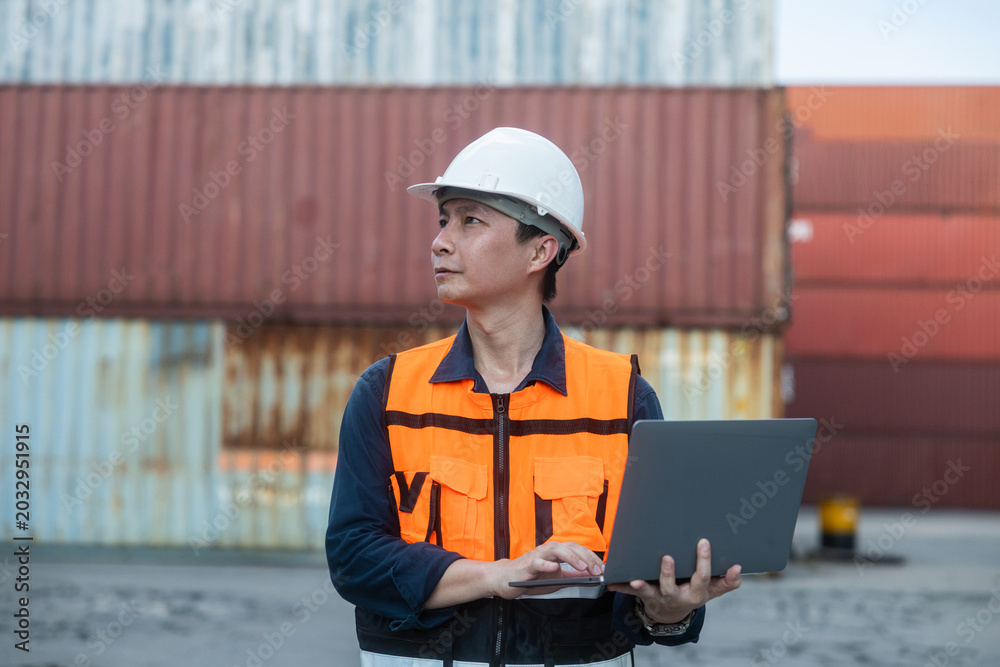 Fototapeta premium Logistics manager using laptop at container yard