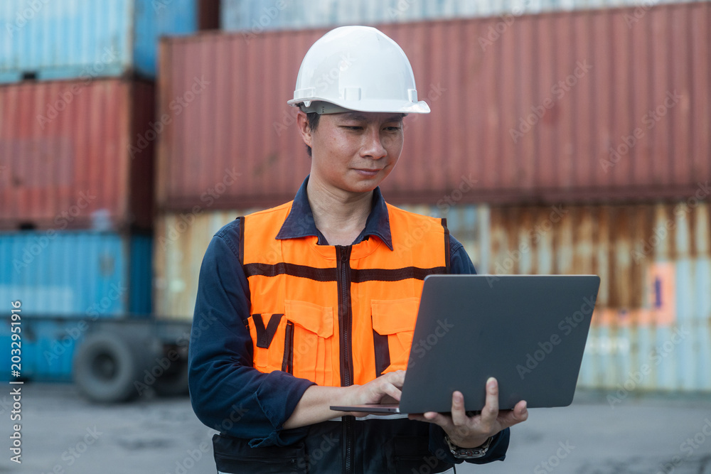 Fototapeta premium Logistics manager using laptop at container yard