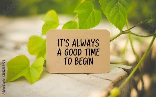 Cardboard sign with the inspirational quote its always a good time to begin placed on wood
