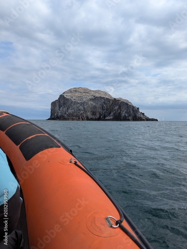 Fotografie A scenic view of Bass Rock, a notable seabird colony in Scotland, from a boat on calm waters