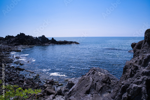 Foto 十六羅漢岩付近から見渡す日本海の青い海と荒々しい岩肌の海岸風景