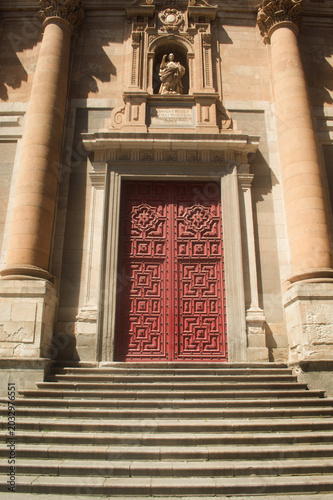 Huge, red cathedral door in Salamanca. Spain.