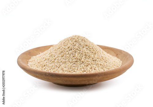 closeup macro shot of white poppy seeds, known as khus khus. This organic ingredient isolated on white background on wooden bowl